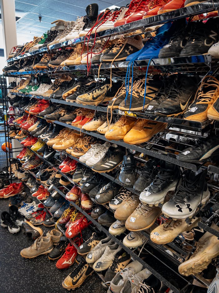 A wide range of sports shoes displayed on shelves in a retail store, showcasing various brands and styles.