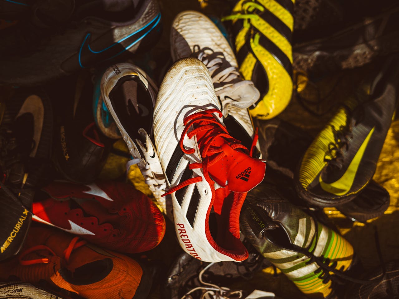 A pile of vibrant and colorful sports sneakers highlighting diverse designs and patterns.